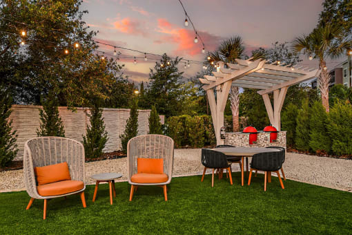 a backyard patio with a table and chairs and a pergola
