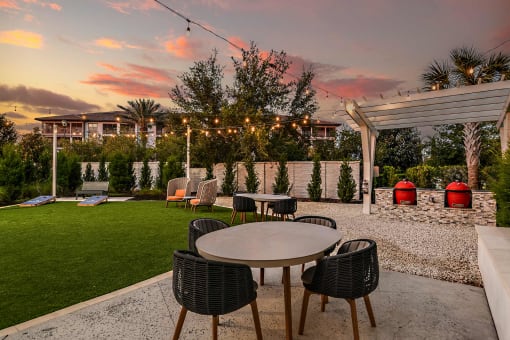 a patio with tables and chairs at sunset
