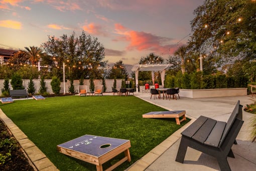 a patio with tables and chairs and a lawn