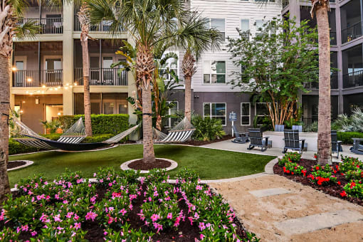 a courtyard with hammocks and flowers in an apartment building