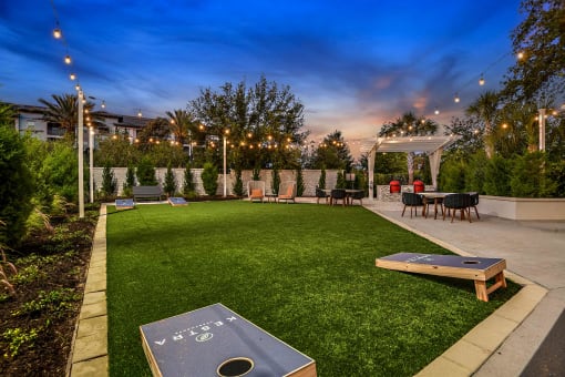 a backyard with a grassy lawn and tables and chairs