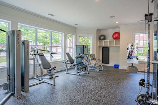 A gym with a variety of equipment including treadmills, weights, and exercise machines.