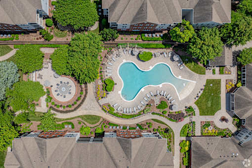 A bird's eye view of a residential area with a swimming pool and a fountain.