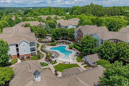 A bird's eye view of a residential area with houses and a swimming pool.