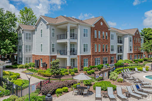 A large apartment complex with a pool and patio area.