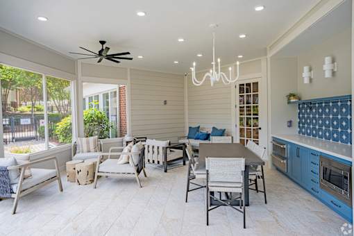A modern kitchen and dining area with a ceiling fan and chandelier.
