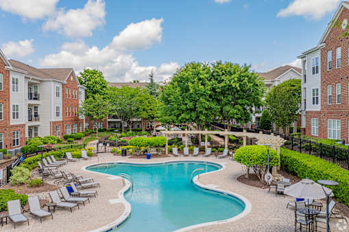 A large swimming pool surrounded by lounge chairs and umbrellas.
