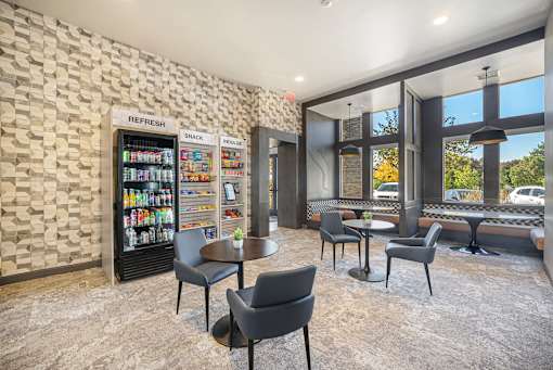 A room with a vending machine and a table with chairs.