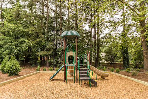 A playground with a green slide and a yellow slide.