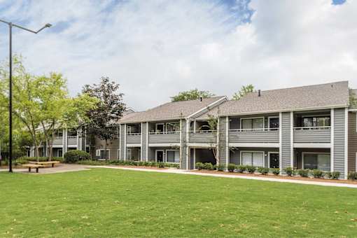A large grassy area in front of apartment buildings.
