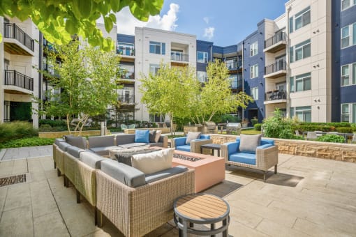 an outdoor patio with couches and tables at the bradley braddock road station apartments