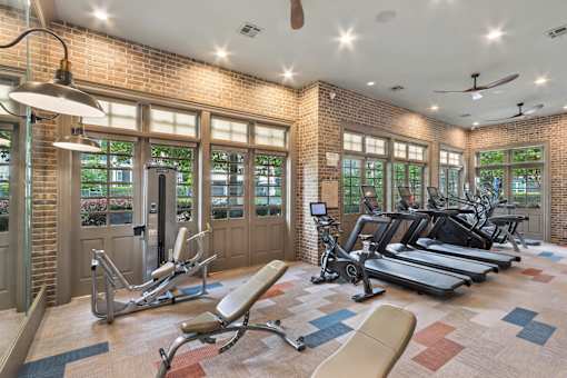 A gym with a brick wall and a variety of exercise equipment.