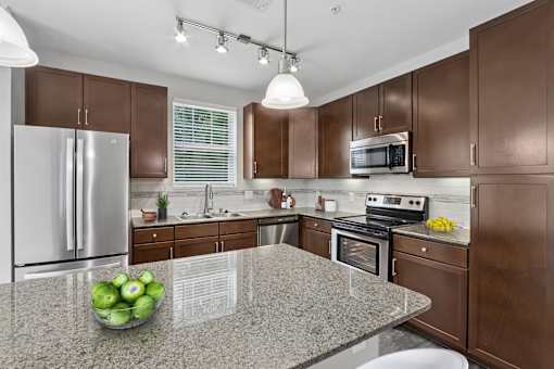 A kitchen with brown cabinets and a granite countertop.