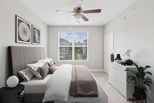 A bedroom with a large bed and a ceiling fan.