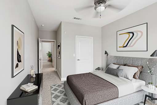 A bedroom with a large bed and a ceiling fan.
