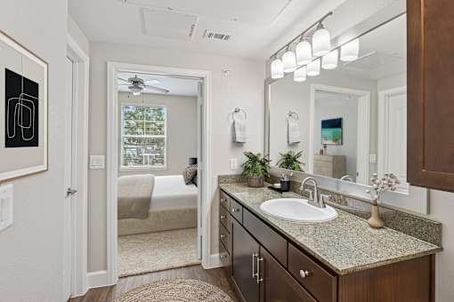 A bathroom with a sink, mirror, and a window.