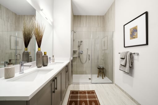 a bathroom with a shower and a sink and a mirror at The Ivy, New Jersey