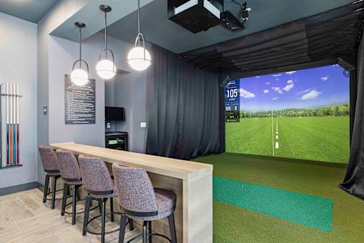 Golf simulator lounge with seating area at The Piermont Apartments, Hillsdale, New Jersey