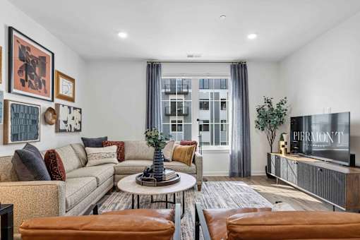 Living room with sectional sofa and gallery wall at The Piermont Apartments, Hillsdale, NJ