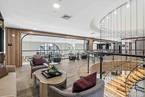 Upper level lounge with circular staircase and seating at The Piermont Apartments, Hillsdale, NJ