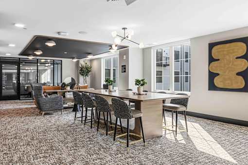 Community workspace with communal table and lounge seating at The Piermont Apartments, Hillsdale, 07642