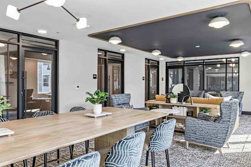 Community dining and lounge area with glass partitions at The Piermont Apartments, Hillsdale, New Jersey