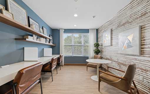 A room with a white table and brown chairs.