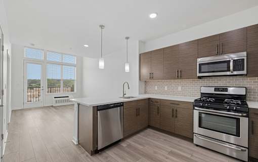 A modern kitchen with stainless steel appliances and wooden cabinets.