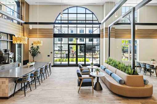 Double height lobby with arched windows and curved sofa at The Piermont Apartments, Hillsdale, NJ