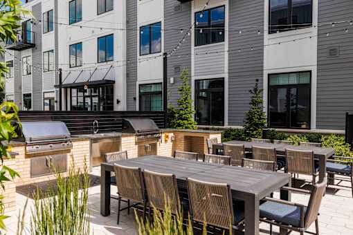 Outdoor kitchen and dining area with grilling stations at The Piermont Apartments, Hillsdale, New Jersey