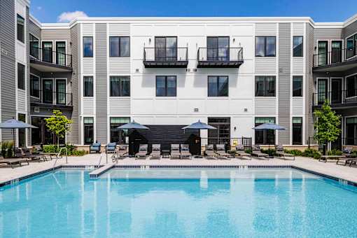 Resort style swimming pool with lounge seating at The Piermont Apartments, Hillsdale, NJ 07642