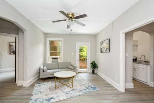 a living room with a couch coffee table and a ceiling fan