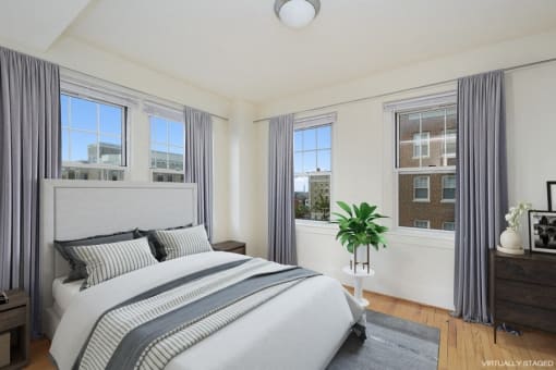a bedroom with a bed and three windows at 1841 Columbia Road Apartments, Washington, DC