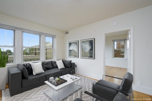 a living room with a black couch and a white coffee table at 1841 Columbia Road Apartments, Washington, DC, 20009