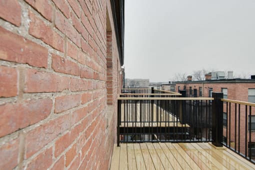 a brick wall with a wooden deck in front of it