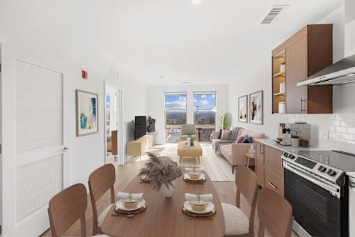 A modern kitchen with a dining table set for two.