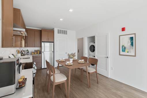 A modern kitchen with a dining table set for two.