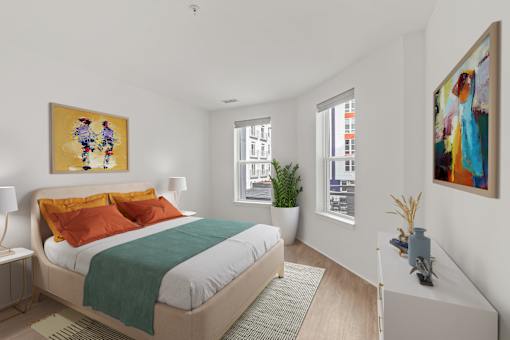 A bedroom with a bed, nightstand, and two paintings on the wall.