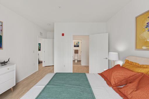 A bedroom with a bed, nightstand, and a painting on the wall.
