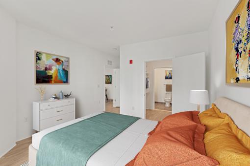 A bedroom with a bed, nightstand, and a painting on the wall.