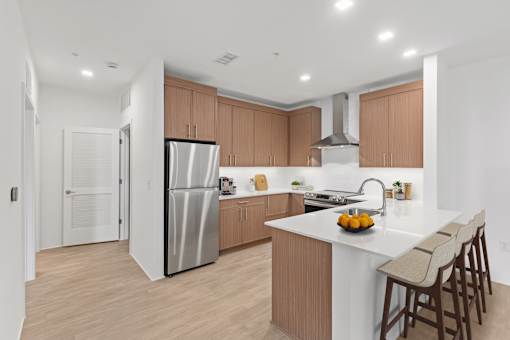 A modern kitchen with a white island and wooden cabinets.