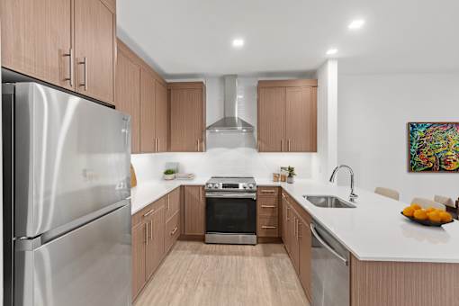 A modern kitchen with wooden cabinets and stainless steel appliances.