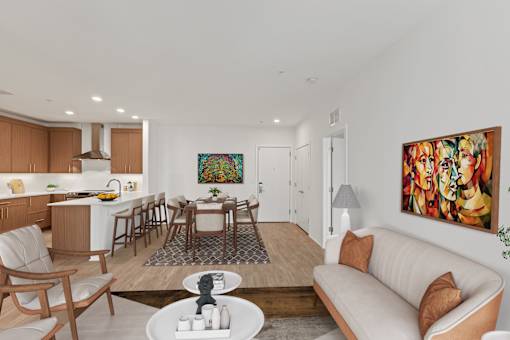 A modern living room with a white couch and a painting on the wall.