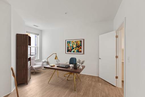 A room with a wooden floor and a painting on the wall.