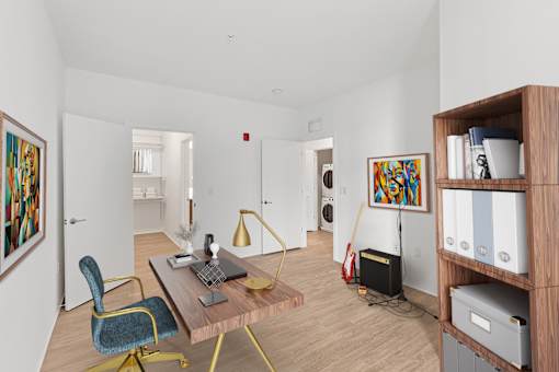 A room with a desk, chair, and bookshelf.