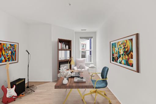 A room with a red guitar, a microphone, a bookshelf, a chair, and two paintings on the wall.