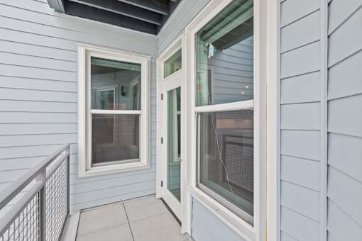 A white door with a window on the side is open.