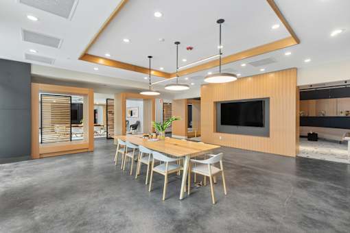 A modern dining room with a long table and chairs.