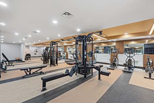 A well-lit gym with various exercise equipment.