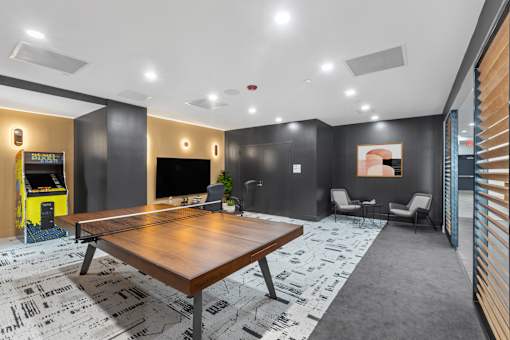 A room with a ping pong table and a foosball table.